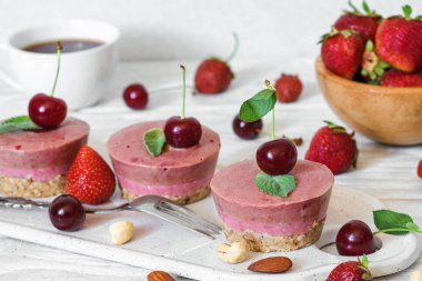 sağlıklı kahvaltı. taze çilek, nane, fındık ve kahve fincanı ile ham çilek ve kiraz kek. vegan gıda kavramı