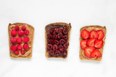 Ekmek fıstık ezmesi ve çikolata yayıldı çilek beyaz mermer tablo ile kadeh. sağlıklı kahvaltı. üstten görünüm