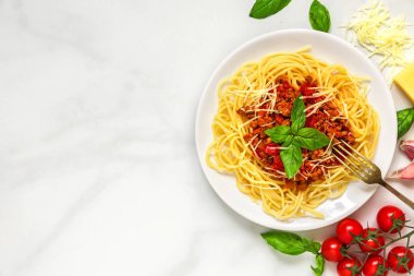 Spagetti bolognese beyaz mermer masada çatal ile beyaz tabakta. sağlıklı gıda. kopya alanı ile üstten görünüm