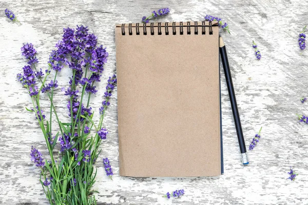 空白老式记事本与薰衣草花卉花束和铅笔在白色的木桌上 顶部视图 — 图库照片