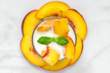 Şeftali yoğurt nane bir cam ile beyaz mermer tablo taze meyve ile. sağlıklı kahvaltı. üstten görünüm