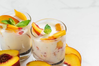 Şeftali yoğurt nane gözlük ile beyaz mermer tablo taze meyve ile. sağlıklı kahvaltı. kopya alanı ile yakın çekim