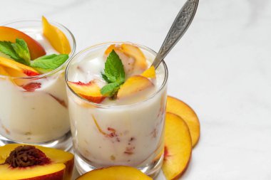 Şeftali yoğurt nane ve kaşık gözlüklü beyaz mermer tablo taze meyve ile. sağlıklı kahvaltı. kopya alanı ile yakın çekim