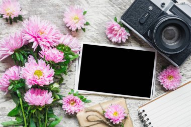 boş fotoğraf çerçevesi ve vintage retro fotoğraf makinesi ile güzel buket pembe aster çiçek, hediye kutusu ve boş not defteri. tatil ya da düğün arka plan. kadar alay et. üstten görünüm