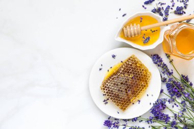 Lavanta çiçekleri ve beyaz mermer masada peteğin tatlım. sağlıklı gıda. kopya alanı ile üstten görünüm