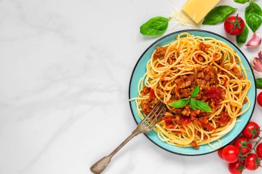 beyaz mermer masada çatal ile makarna spagetti bolognese mavi tabakta. sağlıklı gıda. kopya alanı ile üstten görünüm