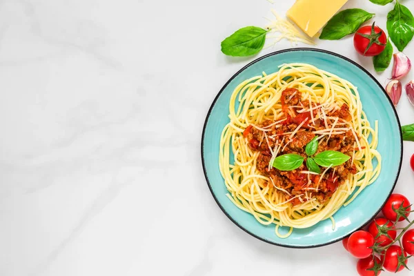 Makarna spagetti bolognese beyaz mermer masada mavi tabakta. sağlıklı gıda. kopya alanı ile üstten görünüm