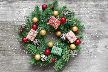 Noel çelenk süsleri ve hediye kutuları rustik ahşap masa üzerinde karla kaplı. üstten görünüm. düz lay