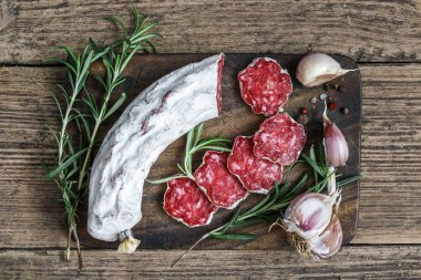 Salam biberiye, sarımsak ve karabiber ahşap kesme tahtası üzerinde rustik arka plan üzerinde Fransız. üstten görünüm. düz lay