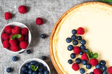 Ev yapımı cheesecake taze ahududu, yaban mersini ve beton zemin üzerine nane. üstten görünüm. lezzetli kahvaltı