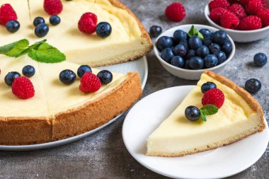 Klasik New York cheesecake taze meyveleri ve taş zemin üzerine nane ile dilimlenmiş, yakın çekim. lezzetli kahvaltı