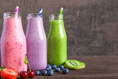 Renkli smoothies şişeleri, sağlıklı detoks vitamini diyet veya vegan meyve, çilek ve payet ile içer. yakın çekim