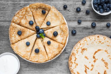 geleneksel Rus krep veya yaban mersini, ekşi krema ve nane ile bliny. Orman meyve ile ince ev yapımı krep yığını. kopya alanı ile üstten görünüm