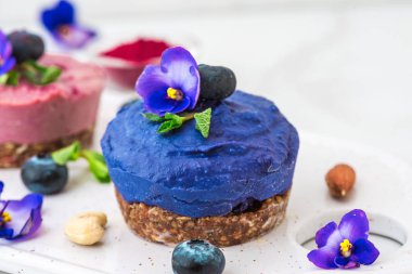 ham yaban mersini, acai ve kelebek bezelye çiçek vegan kek taze çilek ile nane, deli. sağlıklı vegan gıda kavramı. üstten görünüm. düz lay