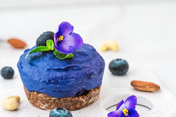 nane, deli yaban mersini ve kelebek bezelye çiçek vegan kaju cheesecake taze çilek, yenilebilir çiçekler, ile. sağlıklı vegan gıda kavramı. üstten görünüm. düz lay