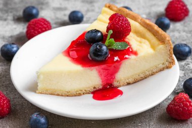 cheesecake taze ahududu, yaban mersini, reçel ve beton zemin üzerine nane ile dilim. yakın çekim. lezzetli kahvaltı