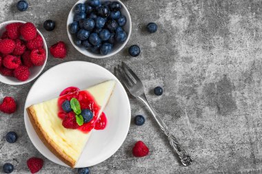 new york cheesecake taze ahududu, yaban mersini, reçel ve nane ile beton zemin üzerine çatal ile dilim. Üstten Görünüm. lezzetli kahvaltı