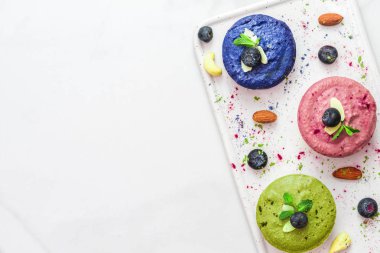 çiğ vegan cheesecakes matcha, acai, kelebek bezelye çay, taze meyveler, nane ve fındık ile ürün yelpazesine. sağlıklı vegan gıda kavramı. Üstten Görünüm. düz lay