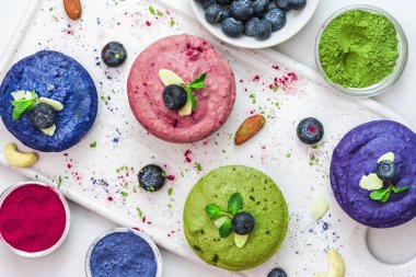 sağlıklı vegan tatlılar. ham kaju kek matcha, acai, yaban mersini, nane ve fındık ile ürün yelpazesine. glutensiz diyet. Üstten Görünüm. düz lay