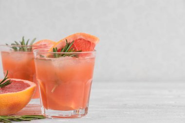 taze greyfurt alkol kokteyl gözlük, buz ve biberiye beyaz zemin üzerine yaz. yakın çekim
