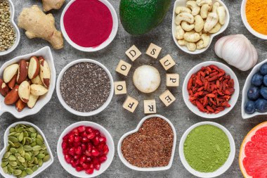 Superfood acai, zerdeçal, matcha, tohum, yaban mersini, goji, zencefil, greyfurt, mantar, nar ve fındık koyu beton arka plan vegan gıda kavramı Üstten Görünüm