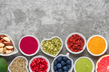 Sağlıklı gıda seçimi yeme temiz: meyve, sebze, tohum, superfood, fındık, çilek gri beton zemin üzerine. Üstten Görünüm kopya alanı ile. vegan gıda
