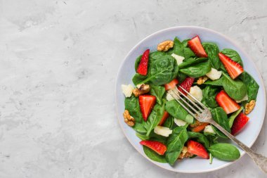 Çilek, ıspanak yaprağı, parmesan peyniri ve ceviz ile taze salata. sağlıklı keto diyet gıda. üst görünüm