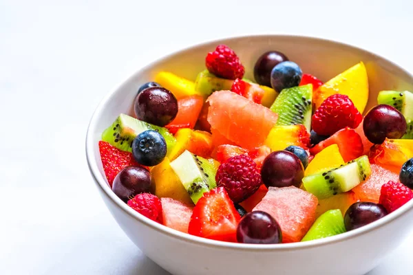 Schüssel mit Sommerfrüchten und Beerensalat auf weißem Marmorhintergrund. gesunde vegane Ernährung — Stockfoto