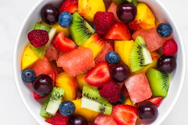 Obstsalat mit Wassermelone, Erdbeere, Kirsche, Blaubeere, Kiwi, Himbeere und Pfirsichen in einer Schüssel. gesunde vegane Ernährung — Stockfoto