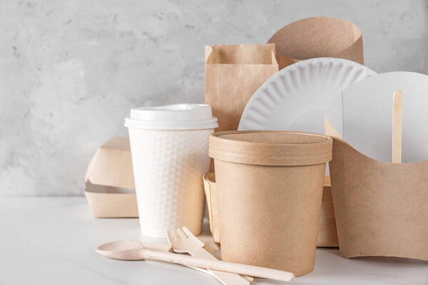 eco friendly disposable dishes made of bamboo wood and paper on white marble background. recycling concept