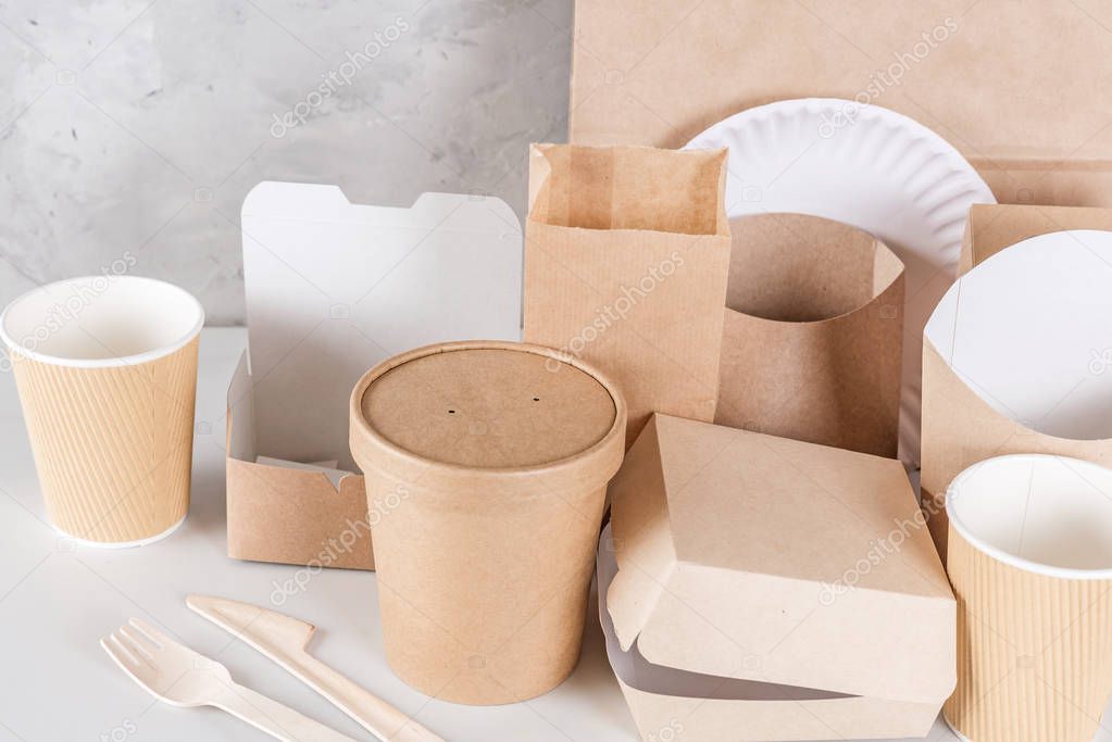 Eco-friendly disposable utensils made of bamboo wood and paper on white marble background