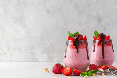 sağlıklı lezzetli kahvaltı için çikolata, taze çilek, granola ve nane ile çilek yoğurt veya chia tohumlu puding