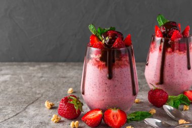 sağlıklı lezzetli kahvaltı için çikolata, taze çilek, granola ve nane ile çilek chia tohumlu puding