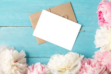 mavi ahşap arka plan üzerinde şakayık çiçek buketi ile boş tebrik kartı ve zarf. düz yatıyordu. alay etmek