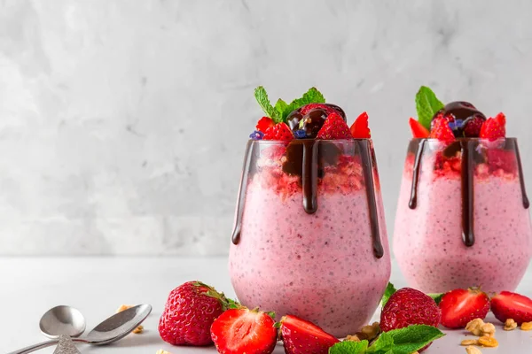 Dos vasos de yogur de fresa o pudín de semillas de chía con chocolate, bayas frescas y menta para un desayuno sabroso y saludable — Foto de Stock