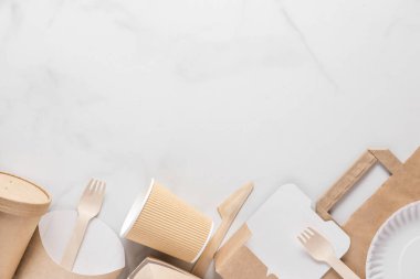 Çevre dostu tek kullanımlık sofra takımı. Kağıt bardaklar, tabaklar, fast food kapları ve bambu ahşap çatal bıçak takımı. Düz yat. en üstteki görünüm
