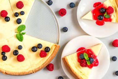 Taze ahududu, yaban mersini, reçel ve naneli iki dilim pastayla birlikte cheesecake. en üstteki görünüm