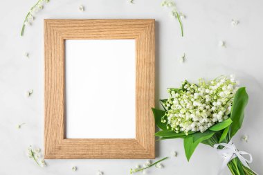 Beyaz arka planda çiçekli zambak demeti olan boş bir fotoğraf çerçevesi. Model yap. Düz yat. Üst Manzara. düğün ya da festival konsepti