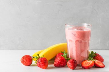 Bir bardak çilekli ve muzlu smoothie veya taze meyve ve meyveli milkshake. Ferahlatıcı bir yaz içeceği. Kapat.