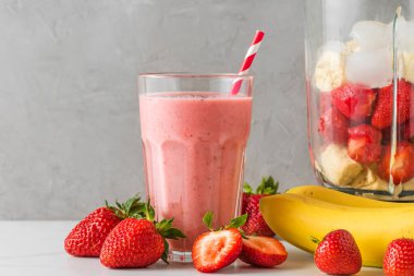 Bir bardak sağlıklı smoothie ya da çilek, muz, badem sütü ve samandan yapılmış milkshake. Çiğ, vejetaryen, vejetaryen, yemek pişirme konsepti