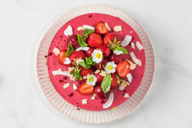 Cevizli, kirazlı, çilekli, hindistancevizli, bademli taze böğürtlenli ve çiçekli çiğ vejetaryen peynirli kek. Lezzetli tatlı. en üstteki görünüm