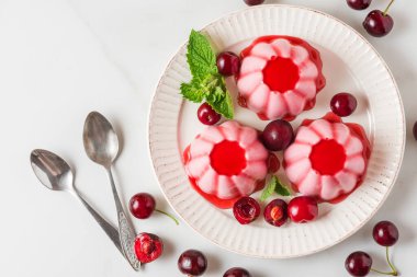 Taze kirazlı panna cotta tatlısı, şurup ve kaşıklı nane şekeri. Sağlıklı İtalyan vejetaryen yemeği. Kopyalama alanı olan üst görünüm