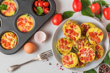 Yumurtalı kek fincanı ya da ıspanak ve domatesli omlet ve çatallı kek tenekesi. Sağlıklı bir diyet kahvaltısı. Yemek konsepti. en üstteki görünüm