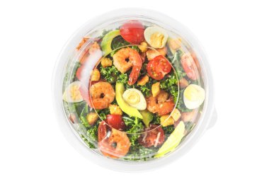 Pakette servis edilen sağlıklı karides sezar salatası ya da beyaz arka planda izole edilmiş yiyecek teslimatı. Üst Manzara. Akdeniz diyeti
