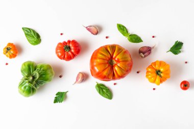 Organik domates desenli bileşim. Beyaz arka planda domates, fesleğen, biber ve sarımsak. Üst Manzara. Düz yat. Vegan diyet yemek pişirme konsepti