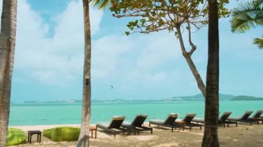 Koh Samui Adası 'ndaki tropik W plajı. Palmiye ağaçlarının altında güneşlenirler, yumuşak altın kum ve turkuaz deniz. Güneşli mavi gökyüzü altında, Tayland. Tatil köyü, plaj tatili, sağlık kaçamakları ve dijital