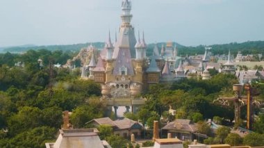 Aerial view of fairy tale castle and amusement park surrounded by lush greenery in Central of Vinwonders theme park Vinpearl on Phu Quoc island, Vietnam. Entertainment promotion, family adventure.