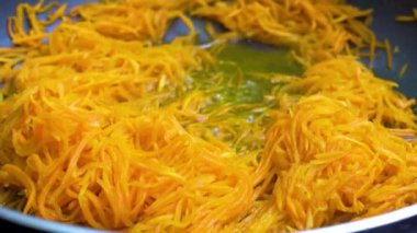 Rendelenmiş havuç yağı bir tavada kızarmış.