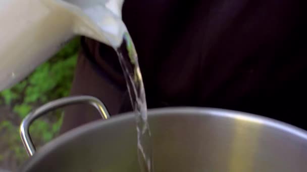 Шеф наливает воду в кастрюлю с овощами — стоковое видео