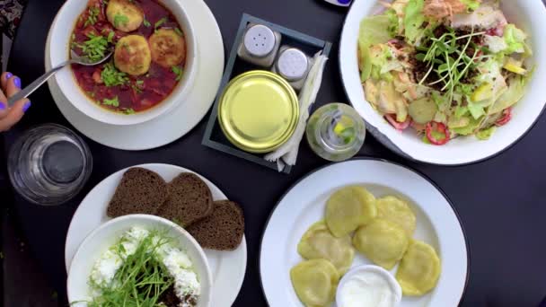 Grupp människor som äter middag på bordet med mat — Stockvideo